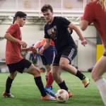 Grinch Gang, red, competes against Black Ice, black, in the finals of the senior division at the annual Holiday Cup Soccer Tournament at the Wells Fargo Dimond Park Field House on Monday, Dec. 31, 2018. The Grinch Gang won 8-2. (Michael Penn | Juneau Empire)