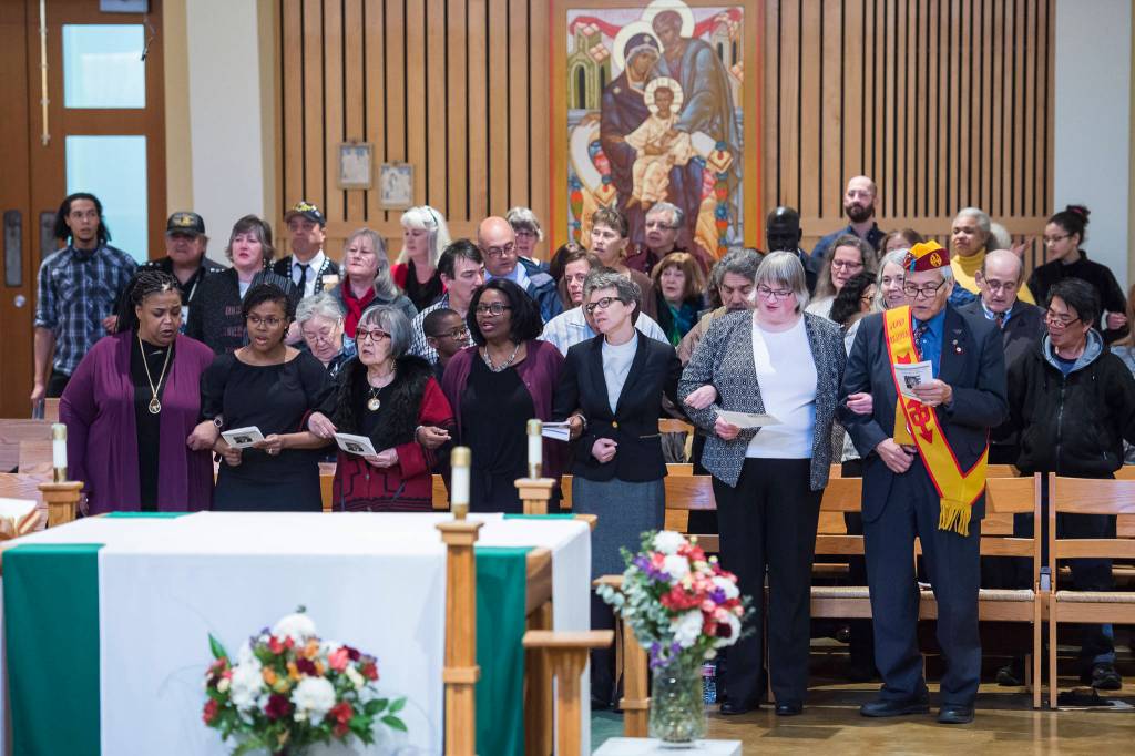 Juneau residents link arms as they sing We Shall Overcome at the Dr. Martin Luther King Jr. 2019 Community Celebration at St. Pauls Catholic Church on Monday, Jan. 21, 2019. (Michael Penn | Juneau Empire)