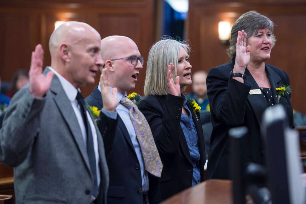 Rep. Dan Ortiz, I-Ketchikan, left, Rep. Jonathan Kreiss-Tomkins, D-Sitka, Rep. Andi Story, D-Juneau, and Rep. Sara Hannan, D-Juneau, take the oath of office on the opening day of the 31st Session of the Alaska Legislature on Tuesday, Jan. 15, 2019. (Michael Penn | Juneau Empire)