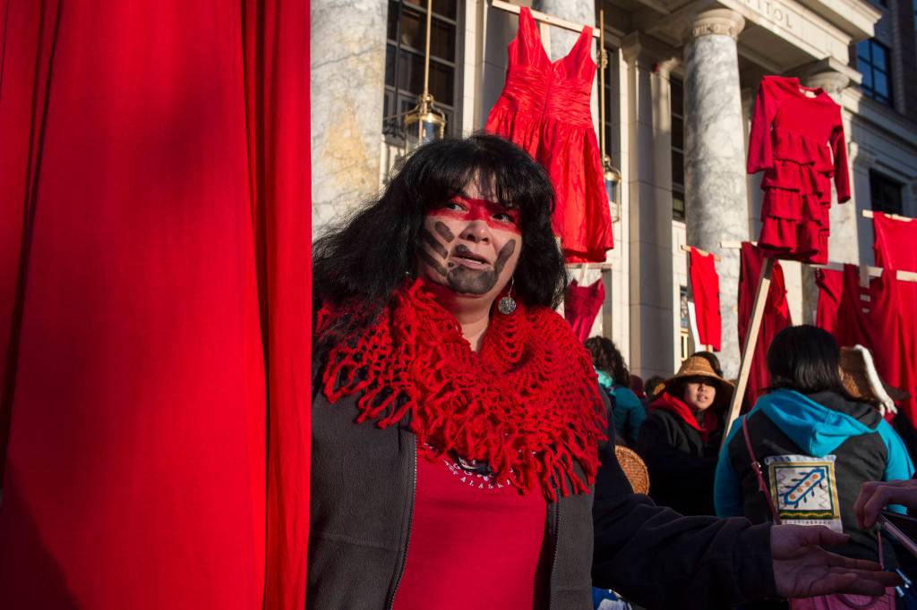Susan Brouillette attends with Native women holding up red dresses to symbolize missing and murdered indigenous women during the Womens March on Juneau in front of the Alaska State Capitol on Saturday, Jan. 19, 2019. (Michael Penn | Juneau Empire)