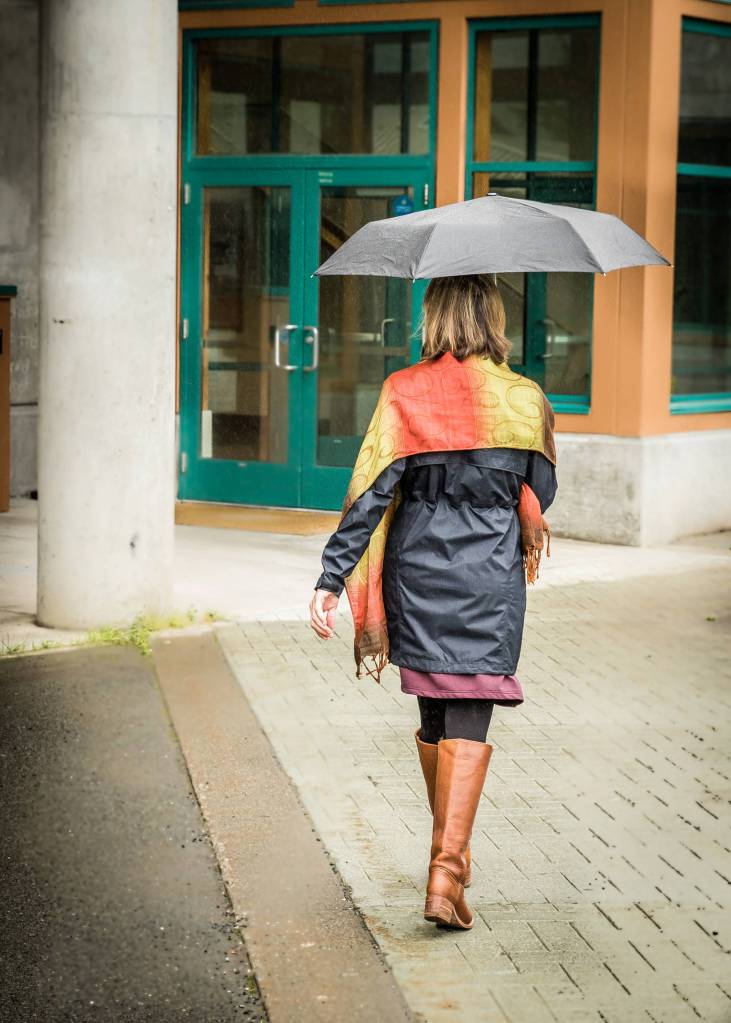 Nov. 4, 2018: This woman reminded me that a spot of color can brighten the grayest of November days. The autumn colors of her dress and scarf  plum, crimson and citron  caught my eye, and her knee-high leather boots suited her outfit perfectly. I also loved the umbrella. Umbrellas are often overlooked in favor of a rain jacket, but they can really save the day, especially in a wet climate.