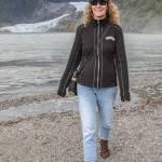Oct. 7, 2018: On this cool day by the glacier, Veronica Sullivan from Chico, California, stayed warm in style. She pairs a wool zip-up jacket from Kuhl and cuff-rolled Gap jeans with brown leather boots from Merrell. Her black wool busker cap, Chico sling purse and Rayban sunglasses complete her practical but trendy look.