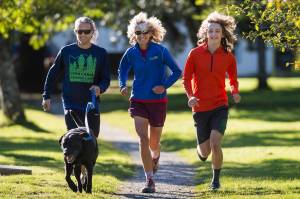 Merry Ellefson, center, runs with her son, Arne Ellefson-Carnes, right, and co-coach Tristan Knutson-Lombardo during Juneau-Douglas High School cross country practice on Wednesday, Sept. 19, 2018. (Michael Penn | Juneau Empire File)