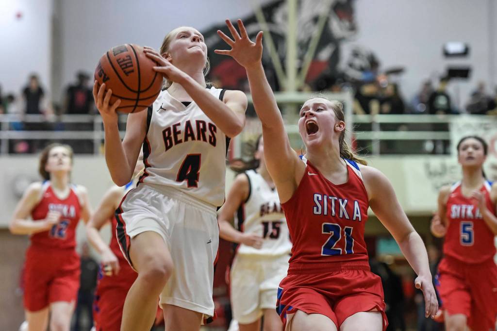 Juneau-Douglas Sadie Tuckwood, left, lays the ball up against Sitkas Kyleigh McArthur at JDHS on Friday, Jan. 25, 2019. Sitka won 37-31. (Michael Penn | Juneau Empire)
