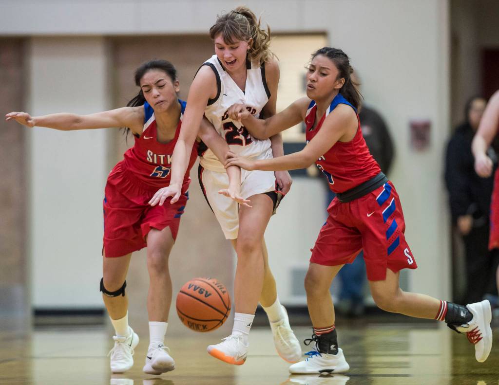 Juneau-Douglas Caitlin Pusich, center, drives between Sitkas Joei Vidad, left, and Tiffan Elefante at JDHS on Friday, Jan. 25, 2019. Sitka won 37-31. (Michael Penn | Juneau Empire)