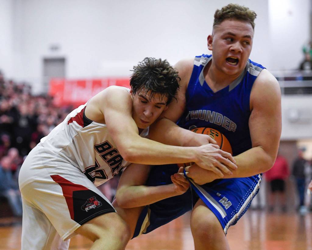 Juneau-Douglas Cooper Kriegmont, left, and Thunder Mountains Vaipuna Toutaiolepo wrestle for the ball at JDHS on Friday, Jan. 25, 2019. Thunder Mountain won 67-63. (Michael Penn | Juneau Empire)