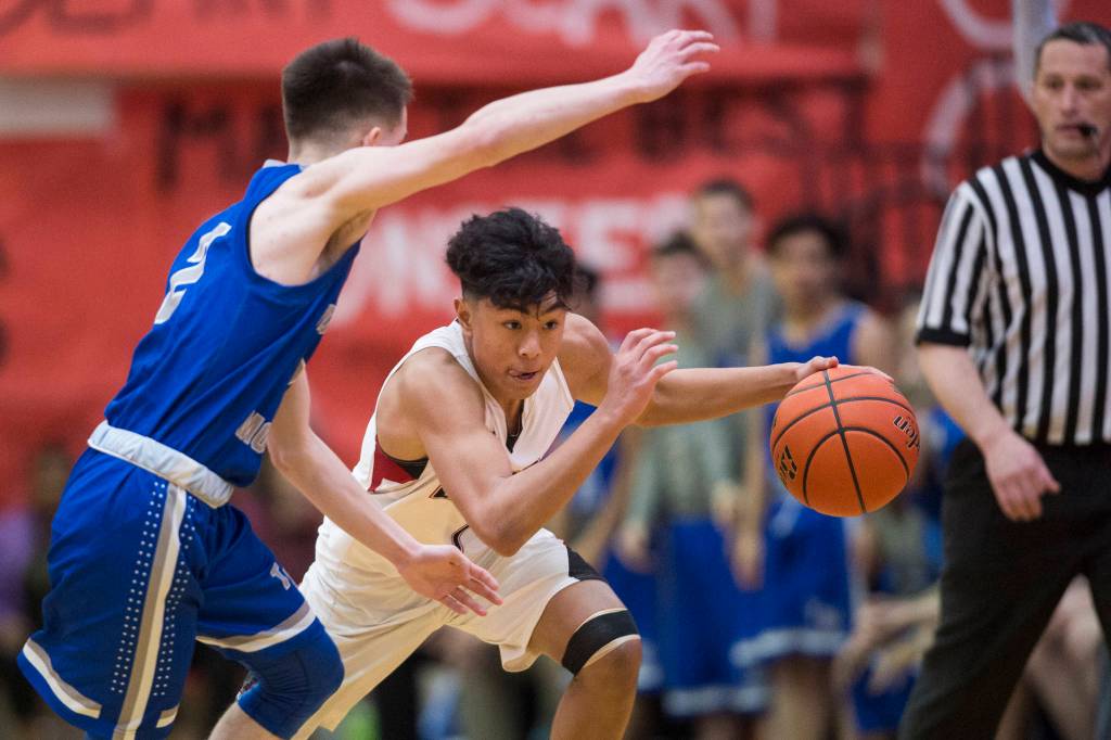 Juneau-Douglas Israel Yadao drives against Thunder Mountains Hansel Hinckle at JDHS on Friday, Jan. 25, 2019. Thunder Mountain won 67-63. (Michael Penn | Juneau Empire)