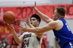 Juneau-Douglas Philip Gonzales, left, is pressured by Thunder Mountains Puna Toutaiolepo at JDHS on Friday, Jan. 25, 2019. After losing on Friday, JDHS won 60-54 on Saturday. (Michael Penn | Juneau Empire File)