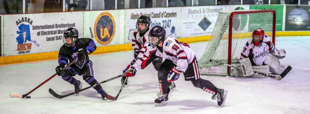 Juneaus Luke Bovitz (68) and Camden Kovach keep Eagle Rivers Adam Kara away from netminder Mason Sooter. (Courtesy Photo | Steve Quinn)