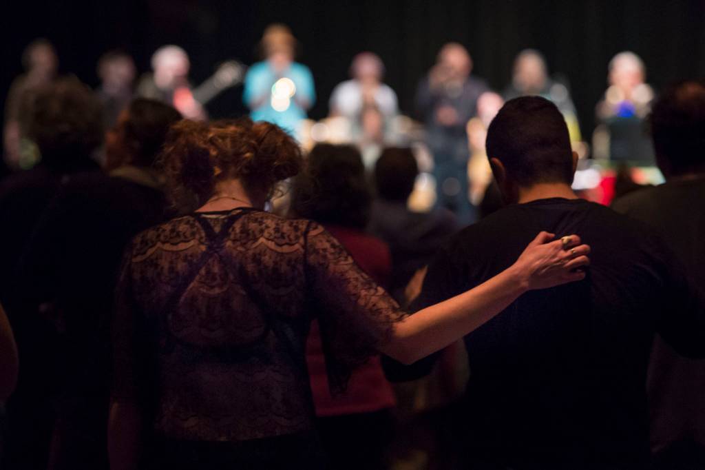 Audience members stand to a prayer song performed by Khu.eex at Centennial Hall on Monday, Jan. 28, 2019. (Michael Penn | Juneau Empire)