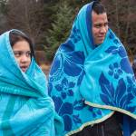 Shawn Jackson and his daughter, Sarah, 10, cover up in towels before taking to the frigid waters at Auke Bay Recreation Area for the annual Juneau Polar Bear Dip on Tuesday, Jan. 1, 2019. Nearly 200 people took the plunge to start off the new year. (Michael Penn | Juneau Empire)