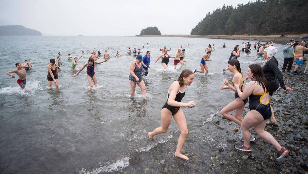 Juneau residents take to the frigid waters at Auke Bay Recreation Area for the annual Juneau Polar Bear Dip on Tuesday, Jan. 1, 2019. Nearly 200 people took the plunge to start off the new year. (Michael Penn | Juneau Empire)
