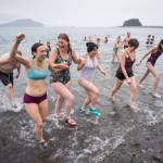 Juneau residents return from the frigid waters at Auke Bay Recreation Area for the annual Juneau Polar Bear Dip on Tuesday, Jan. 1, 2019. Nearly 200 people took the plunge to start off the new year. (Michael Penn | Juneau Empire)
