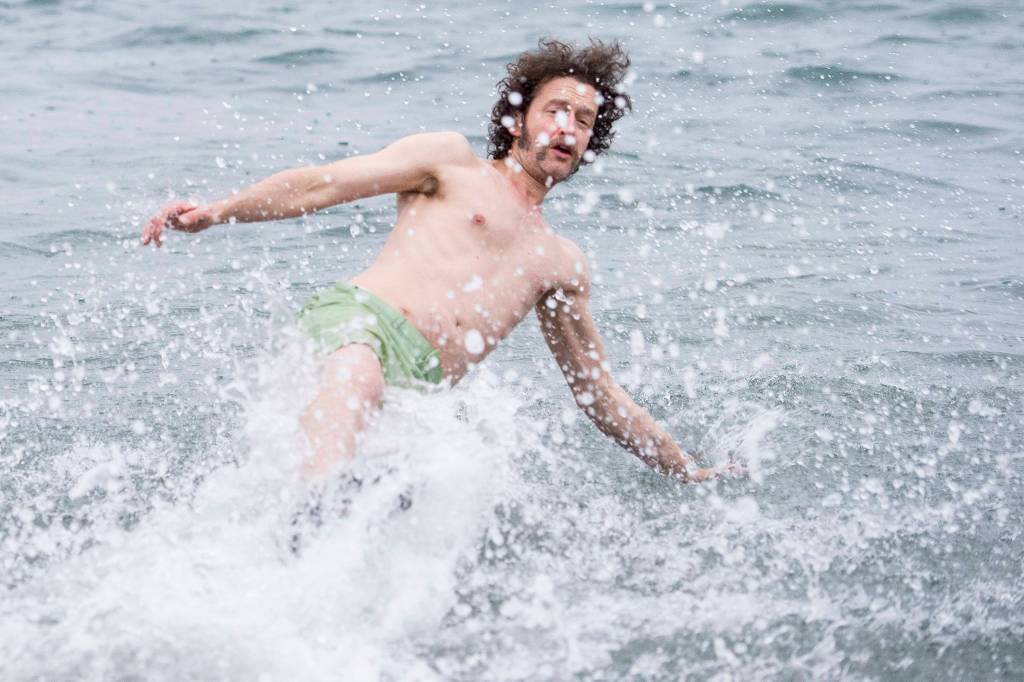George Kuhar takes a enthusiastic plunge into the frigid waters at Auke Bay Recreation Area for the annual Juneau Polar Bear Dip on Tuesday, Jan. 1, 2019. Nearly 200 people took the plunge to start off the new year. (Michael Penn | Juneau Empire)