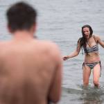 Christopher McGee photographs his wife, Damaras, as she returns from the frigid waters at Auke Bay Recreation Area for the annual Juneau Polar Bear Dip on Tuesday, Jan. 1, 2019. Nearly 200 people took the plunge to start off the new year. (Michael Penn | Juneau Empire)