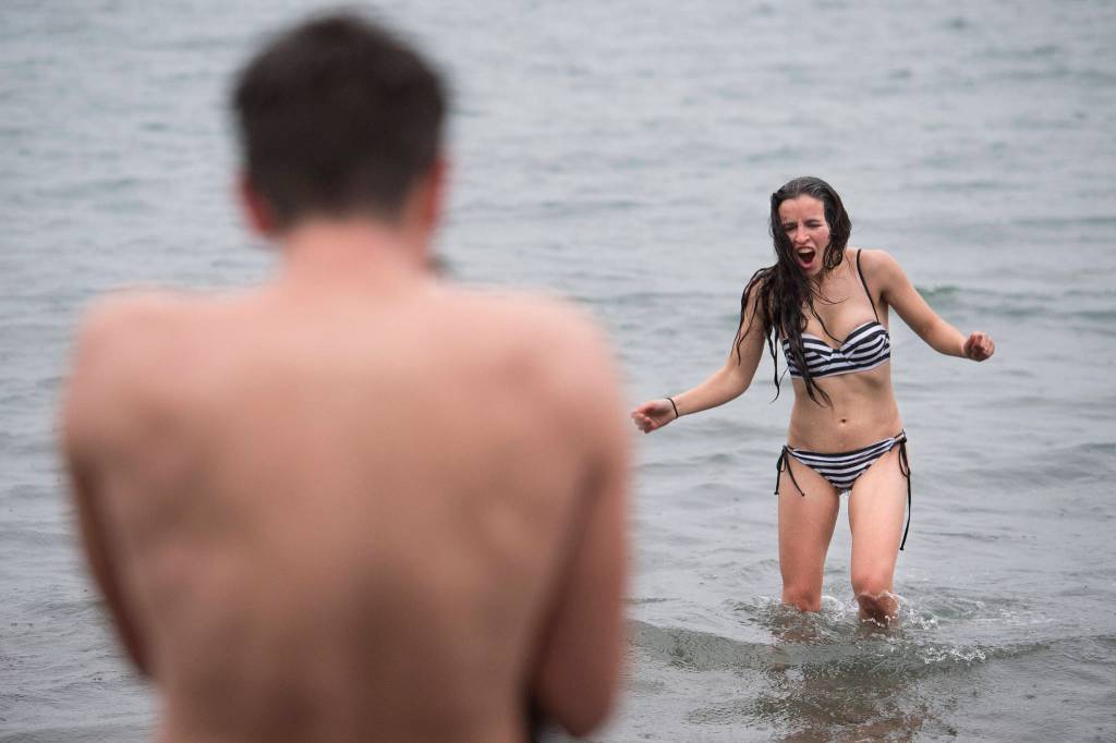 Christopher McGee photographs his wife, Damaras, as she returns from the frigid waters at Auke Bay Recreation Area for the annual Juneau Polar Bear Dip on Tuesday, Jan. 1, 2019. Nearly 200 people took the plunge to start off the new year. (Michael Penn | Juneau Empire)