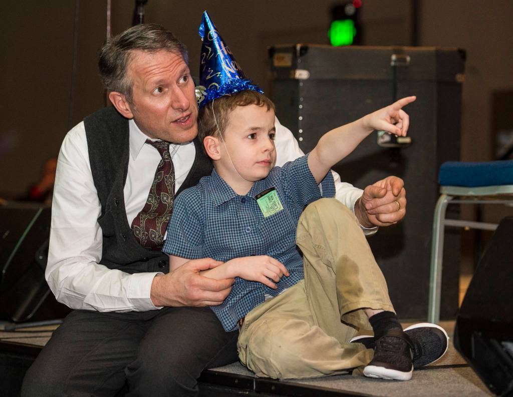 Sean Boily watches the activities with his son, Axel, 9, at the New Years Eve Gala at Centennial Hall on Monday, Dec. 31, 2018. The event was a fundraiser for the Juneau Arts and Humanities Council and Juneau Jazz & Classics. (Michael Penn | Juneau Empire)