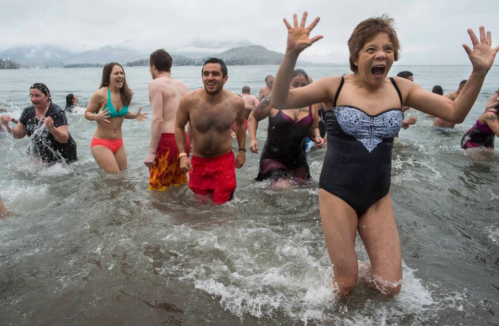 Juneau residents react to the 37 degree water temperature during the annual Polar Bear Dip at Auke Recreation beach on Monday, Jan. 1, 2018.