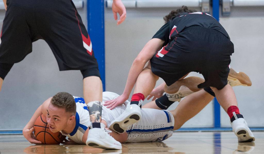 Thunder Mountains Vaipuna Toutaiolepo dives for a loose ball against Juneau-Douglas Cooper Kriegmont during their game at TMHS on Friday, Jan. 5, 2017. TMHS won 50-45.