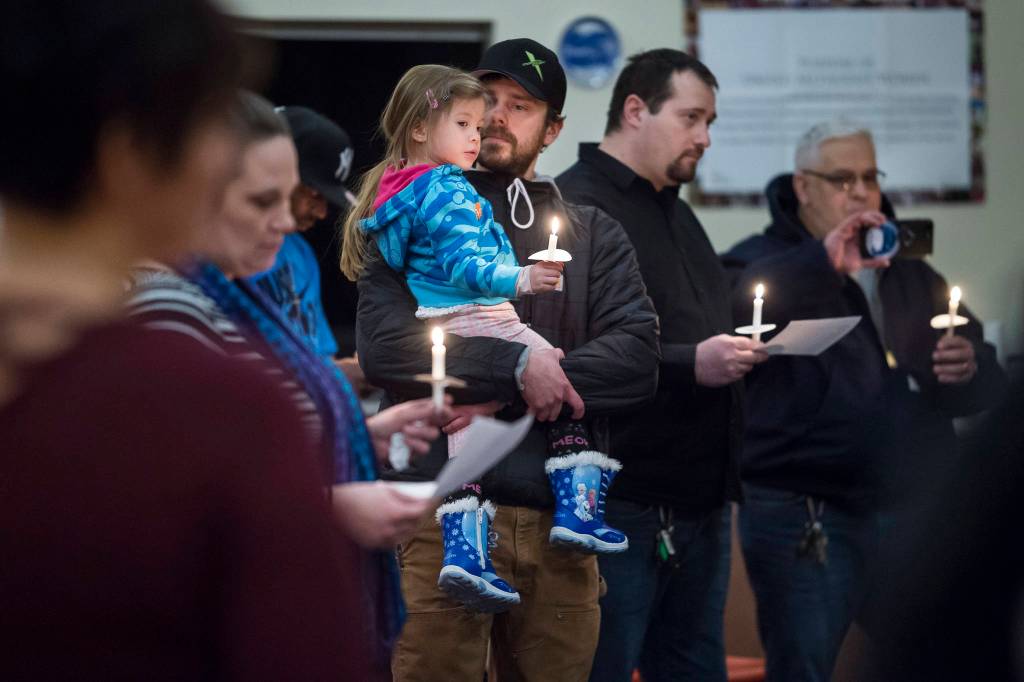 William James Musser V holds his daughter, Annabelle Rose, 4, as they attend a candlelight vigil with about 40 other people at Northern Light United Church on Wednesday, Jan. 10, 2018. The Juneau Reentry Coalition sponsored the event as part of a statewide collaboration remembering people lost to addiction.