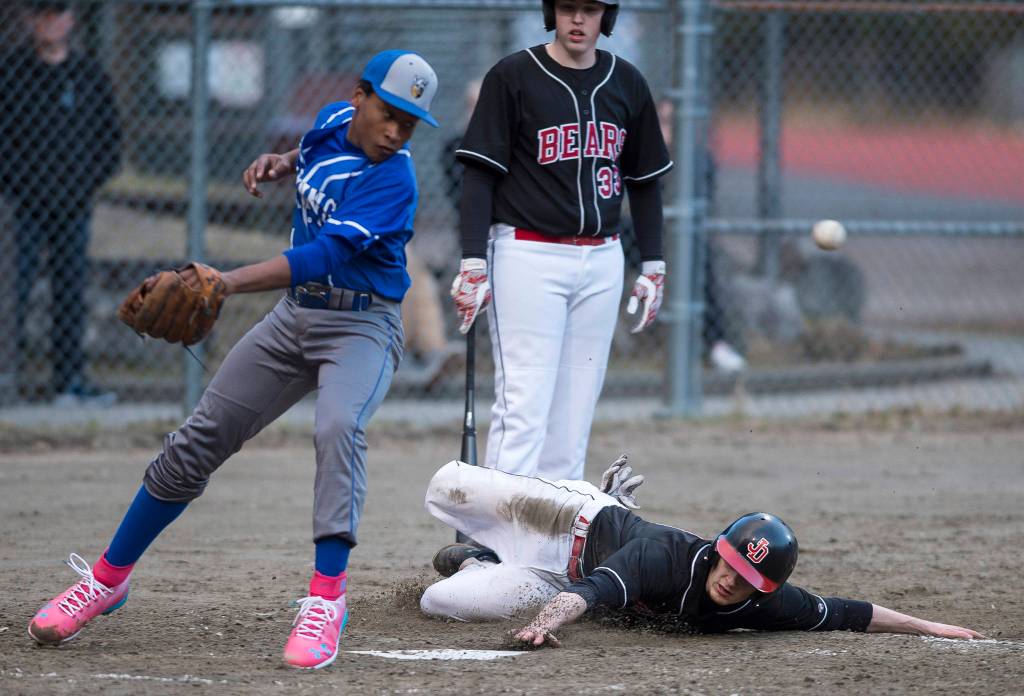 Juneau-Douglas Jacob Dale slides to steal home and score as Petersburgs Sawyer Bryner misses the throw at Adair-Kennedy Memorial Park on Friday, April 27, 2018. (Michael Penn | Juneau Empire)