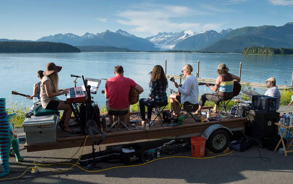 Juneau residents listen to the music of Papertrails and enjoy the beach during a solstice party at the North Douglas Boat Launch on Wednesday, June 20, 2018. (Michael Penn | Juneau Empire)