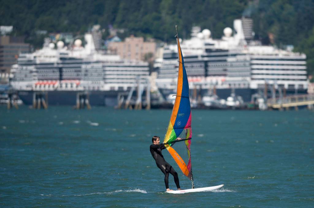 Greg Albricht takes advantage of a steady breeze to windsurf downtown on Monday, July 30, 2018. (Michael Penn | Juneau Empire)
