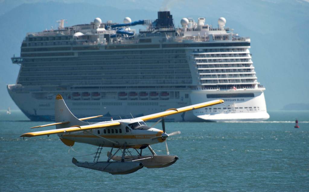A Wings Airways floatplane takes off from Juneaus downtown harbor as the Norwegian Bliss leaves it port of call on Tuesday, July 31, 2018. (Michael Penn | Juneau Empire)