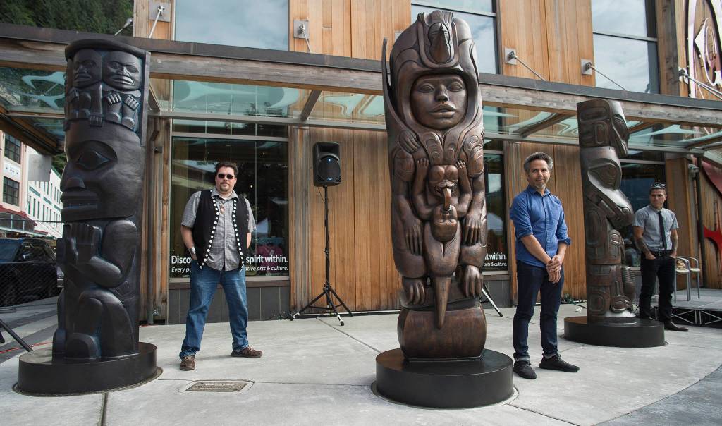 Tsimshian artist David R. Boxley, left, Tlingit artist Stephen Jackson, center, and Haida artist TJ Young, stand by their bronze house posts during an unveiling ceremony in front of the Walter Soboleff Center by Sealaska Heritage Institute on Sunday, Aug. 26, 2018. (Michael Penn | Juneau Empire)