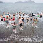 Juneau residents take to the frigid waters at Auke Bay Recreation Area for the annual Juneau Polar Bear Dip on Tuesday, Jan. 1, 2019. Nearly 200 people took the plunge to start off the new year. (Michael Penn | Juneau Empire)