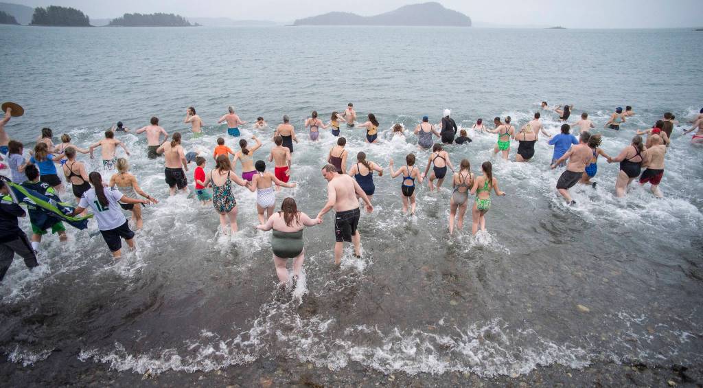Juneau residents take to the frigid waters at Auke Bay Recreation Area for the annual Juneau Polar Bear Dip on Tuesday, Jan. 1, 2019. Nearly 200 people took the plunge to start off the new year. (Michael Penn | Juneau Empire)