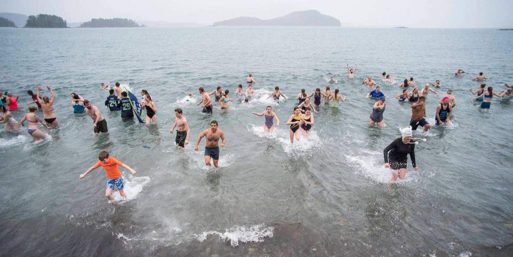 Juneau residents take to the frigid waters at Auke Bay Recreation Area for the annual Juneau Polar Bear Dip on Tuesday, Jan. 1, 2019. Nearly 200 people took the plunge to start off the new year. (Michael Penn | Juneau Empire)