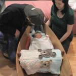 Yakutat residents Cody Kunau and Samantha Munoz sit with their baby Saige Roisin Kuneau on Friday, Jan. 4 at Bartlett Regional Hospital. Saige was the first baby born at the hospital this year, and received a boat carved by BRH Emergency Room Dr. Lindy Jones. (Alex McCarthy | Juneau Empire)