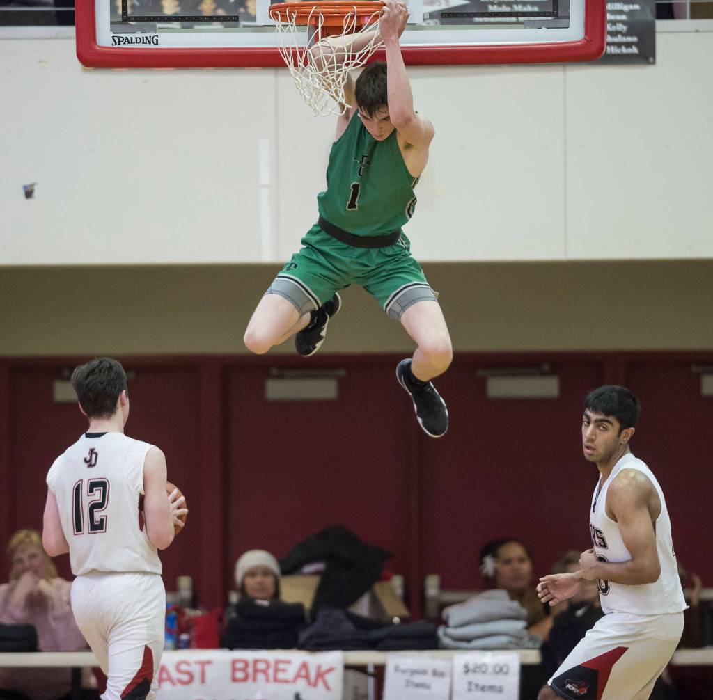 Colonys Patrick McMahon, center, finishes a dunk between Juneau-Douglas Brock McCormick, left, and Krishant Samtani at JDHS on Thursday, Jan. 10, 2019. Colony won 66-40. (Michael Penn | Juneau Empire)