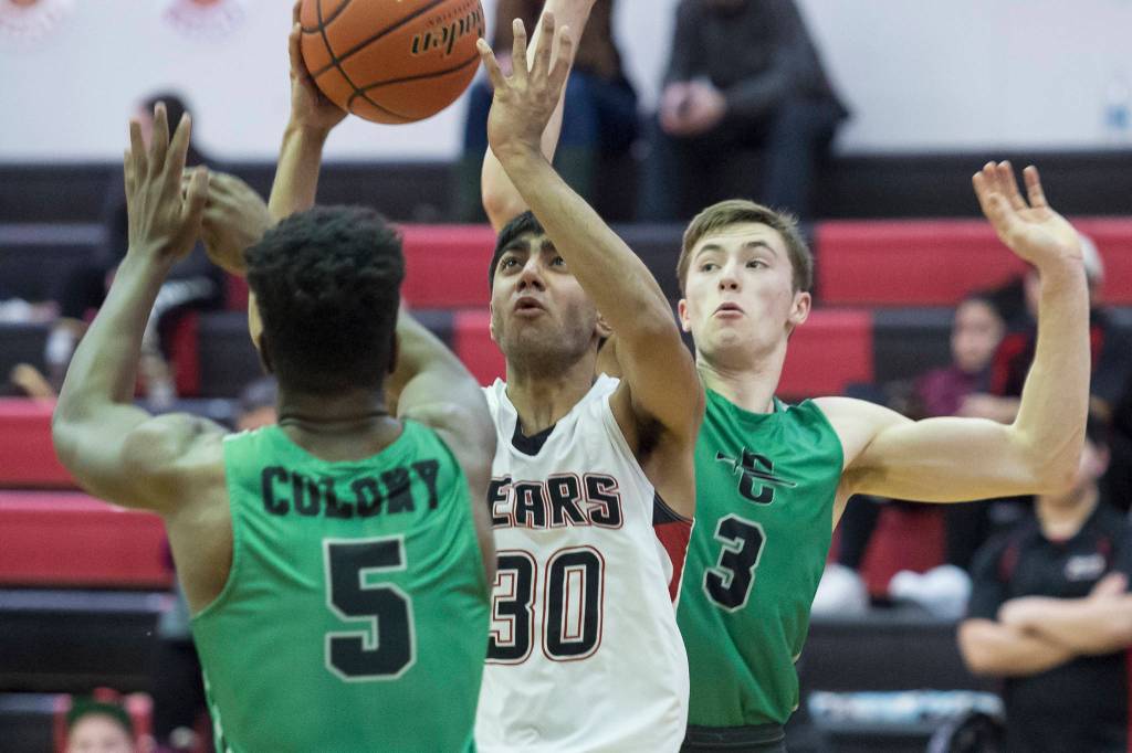 Juneau-Douglas Krishant Samtani, center, puts up a shot against pressure by Colonys Julian McPhail, left, and Sullivan Menard at JDHS on Thursday, Jan. 10, 2019. Colony won 66-40. (Michael Penn | Juneau Empire}