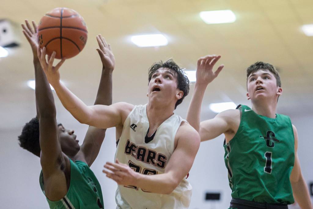 Juneau-Douglas Cooper Kriegmont put up a shot against Colonys Julian McPhail, left, and Patrick McMahon at JDHS on Thursday, Jan. 10, 2019. Colony won 66-40. (Michael Penn | Juneau Empire}