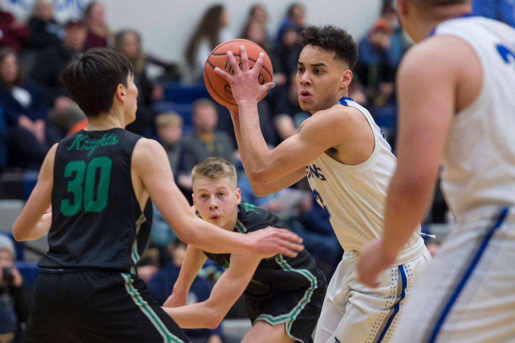 Thunder Mountains Kamron Falls, right, is pressured by Colonys Jeremiah Hersrud, left, and Colton Spencer at TMHS on Friday, Jan. 11, 2019. Colony won 46-27. (Michael Penn | Juneau Empire)