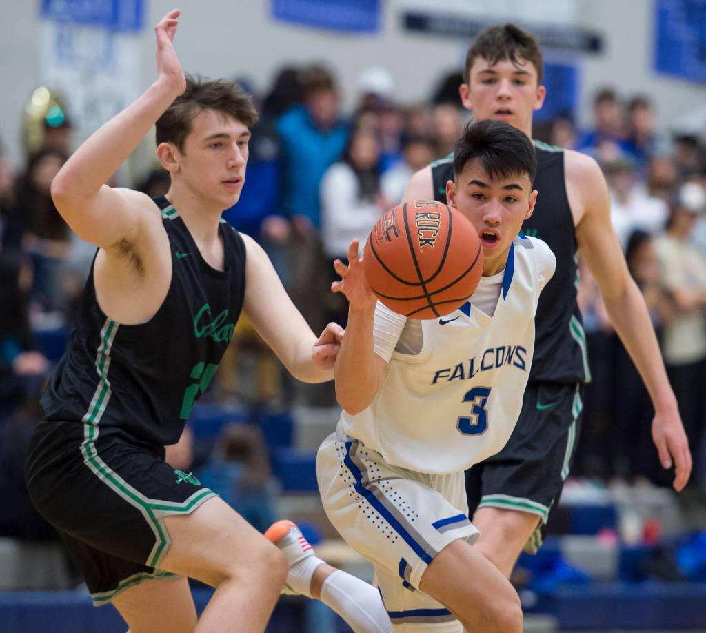 Thunder Mountains Bryson Echiverri, center, drives between Colonys Max Escobedo, left, and Patrick McMahon at TMHS on Friday, Jan. 11, 2019. Colony won 46-27. (Michael Penn | Juneau Empire)