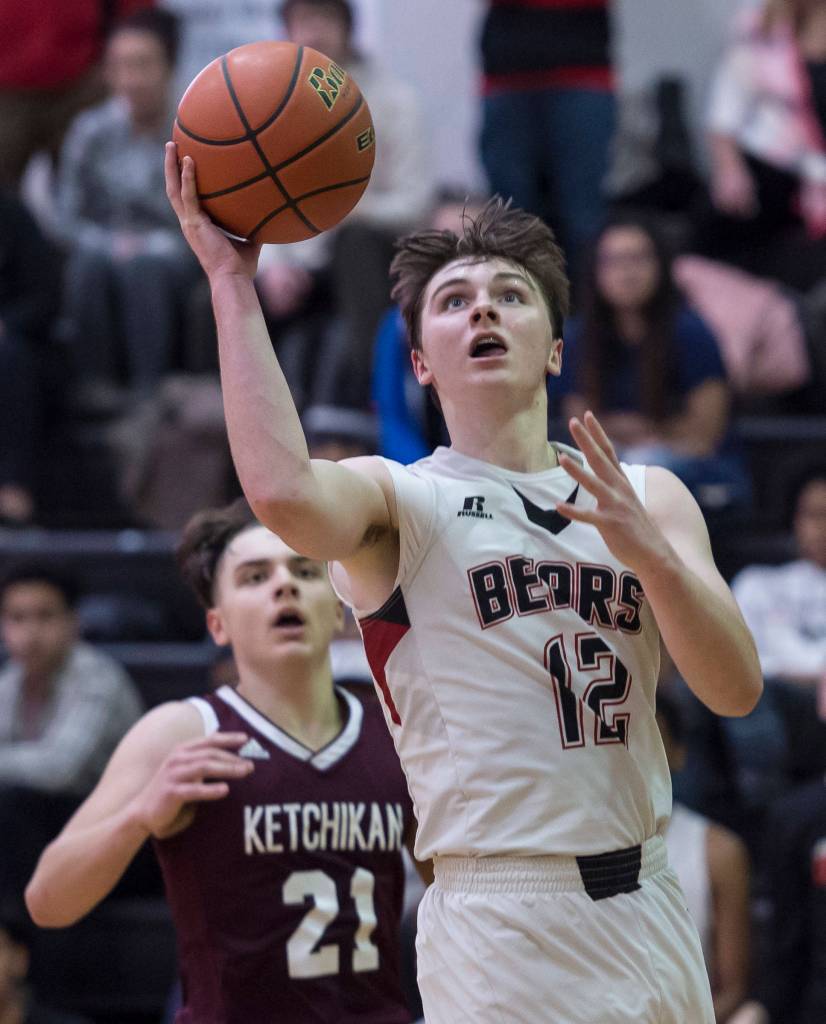 Juneau-Douglas Brock McCormick, right, lays the ball up against Ketchikans Kristian Pihl at JDHS on Friday, Jan. 11, 2019. JDHS won 75-67. (Michael Penn | Juneau Empire)
