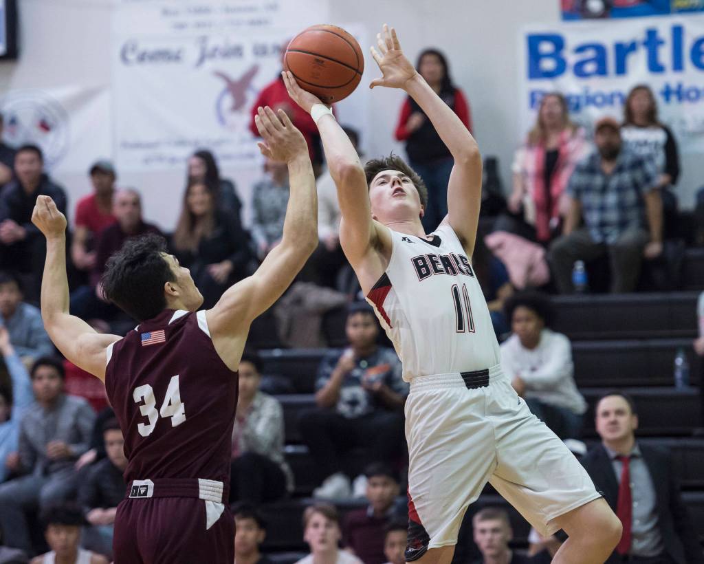 Juneau-Douglas Garrett Bryant shoots over Ketchikans Robert Hilton Seludo at JDHS on Friday, Jan. 11, 2019. JDHS won 75-67. (Michael Penn | Juneau Empire)