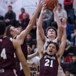 Juneau-Douglas Garrett Bryant rebounds against Ketchikans Jake Taylor, left, and Kristian Pihl at JDHS on Friday, Jan. 11, 2019. JDHS won 75-67. (Michael Penn | Juneau Empire)