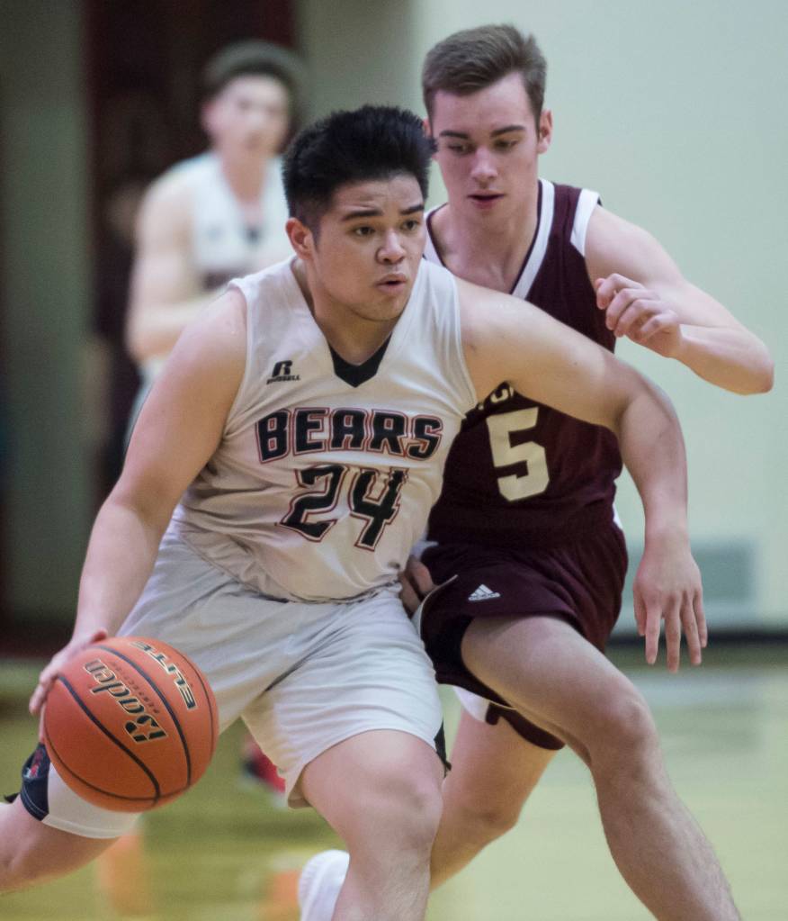 Juneau-Douglas Philip Gonzales, left, drives against Ketchikans Jake Taylor at JDHS on Friday, Jan. 11, 2019. JDHS won 75-67. (Michael Penn | Juneau Empire)