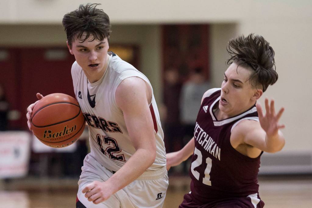 Juneau-Douglas Brock McCormick, left, drives against Ketchikans Kristian Pihl at JDHS on Friday, Jan. 11, 2019. JDHS won 75-67. (Michael Penn | Juneau Empire)