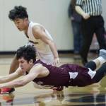 Ketchikans James Nordlund dives for the ball against Juneau-Douglas Israel Yadao at JDHS on Friday, Jan. 11, 2019. JDHS won 75-67. (Michael Penn | Juneau Empire)