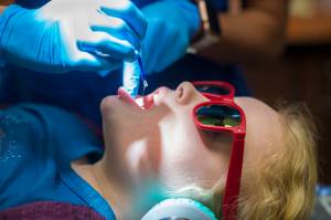 Tynly Booth, 8, holds still as Dr. Jessica Branco, of Juneau Pediatric Dentistry, applies a topical flouride varnish during a checkup on Monday, Jan. 14, 2019. (Michael Penn | Juneau Empire)