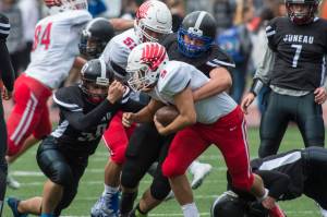 Juneau Footballs Maikeli Tupou, left, Puna Toutaiolepo, center, and Caleb Traxler, right, tackle Easts Jason Jenn-Lundfelt at Adair-Kennedy Memorial Field on Saturday, Aug. 25, 2018. East won 40-0. (Michael Penn | Juneau Empire File)
