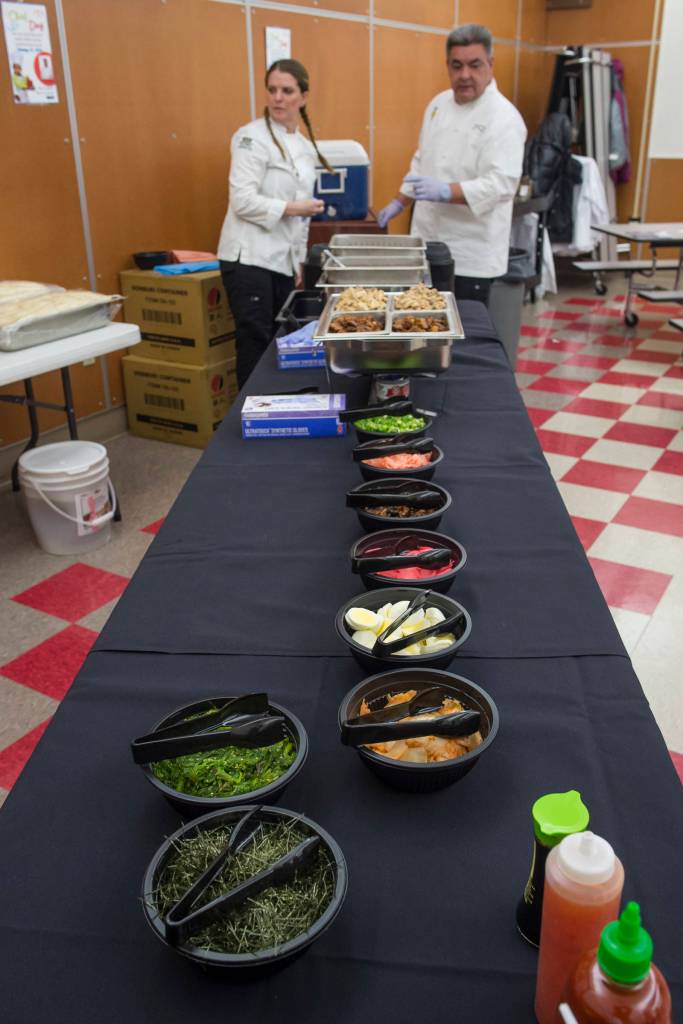 Chefs Naomi Everett, left, and Matt Little Dog set up a food line featuring authentic Japanese ramen for students at Floyd Dryden Middle School as part of Chefs Day on Friday, Jan. 18, 2019. The Anchorage chefs visiting the Juneau and Sitka School Districts to introduced new and healthy foods via performance cooking demonstrations. (Michael Penn | Juneau Empire)