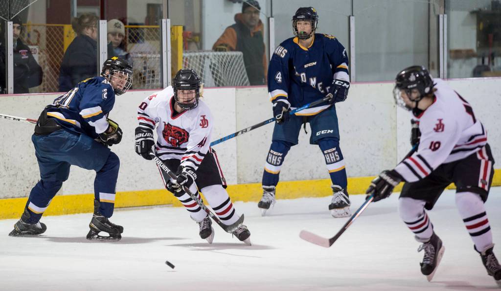Juneau-Douglas Ethan Welch passes to teammate Dalton Hoy against Homer at Treadwell Arena on Friday, Jan. 18, 2019. JDHS won 4-3 in overtime. (Michael Penn | Juneau Empire)