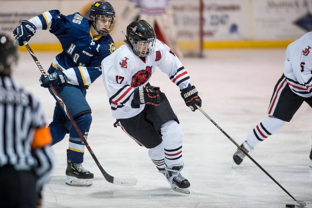 Juneau-Douglas Bill Bosse, right, moves the puck against Homers Ethan Pitzman at Treadwell Arena on Friday, Jan. 18, 2019. JDHS won 4-3 in overtime. (Michael Penn | Juneau Empire)