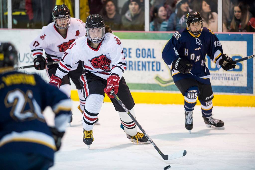 Juneau-Douglas Chance Turinsky, center, moves the puck against Homer at Treadwell Arena on Friday, Jan. 18, 2019. JDHS won 4-3 in overtime. (Michael Penn | Juneau Empire)